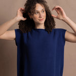 A lady wears a pure 100% cashmere tee sweater jumper in blue over bright pink silk trousers