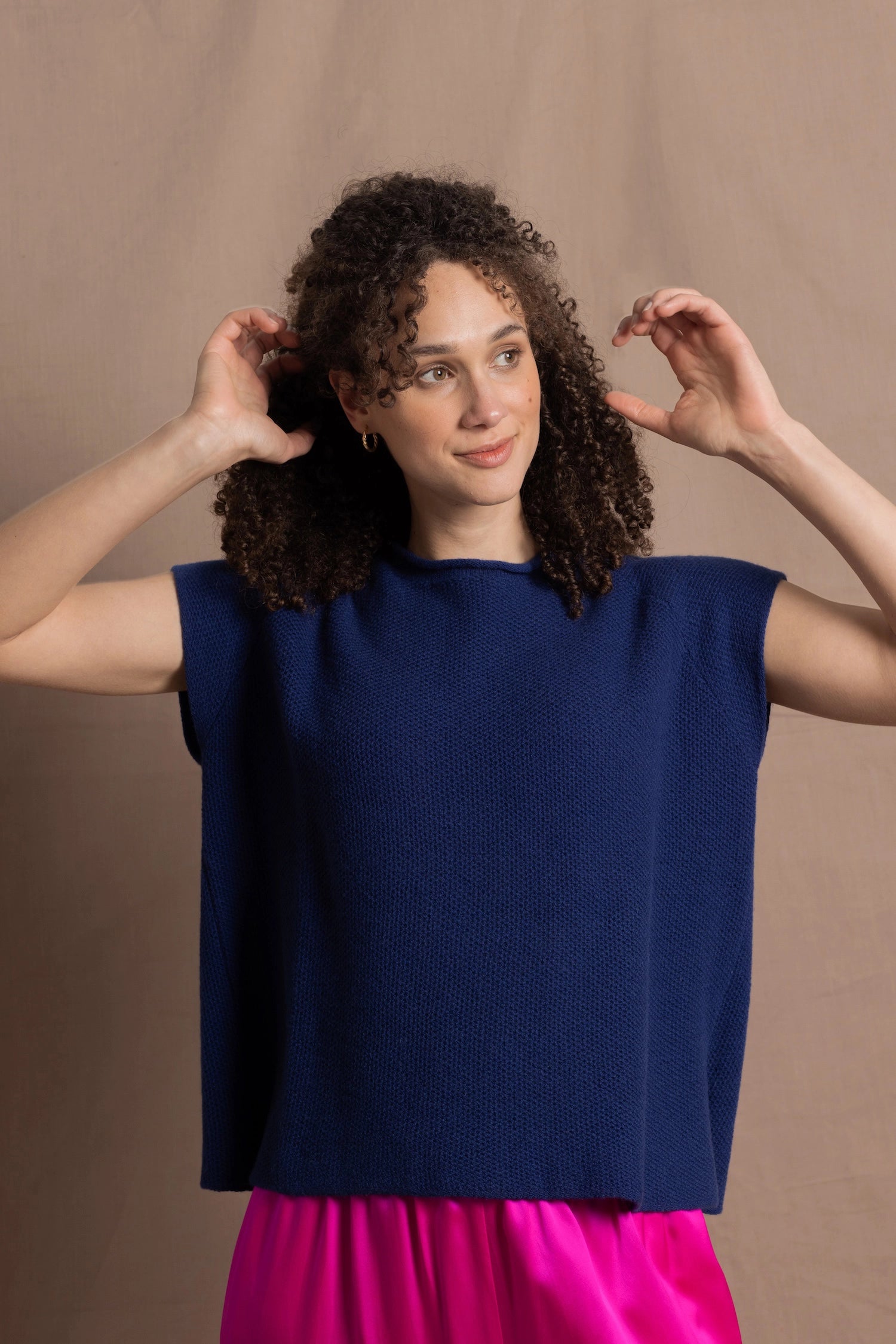 A lady wears a pure 100% cashmere tee sweater jumper in blue over bright pink silk trousers