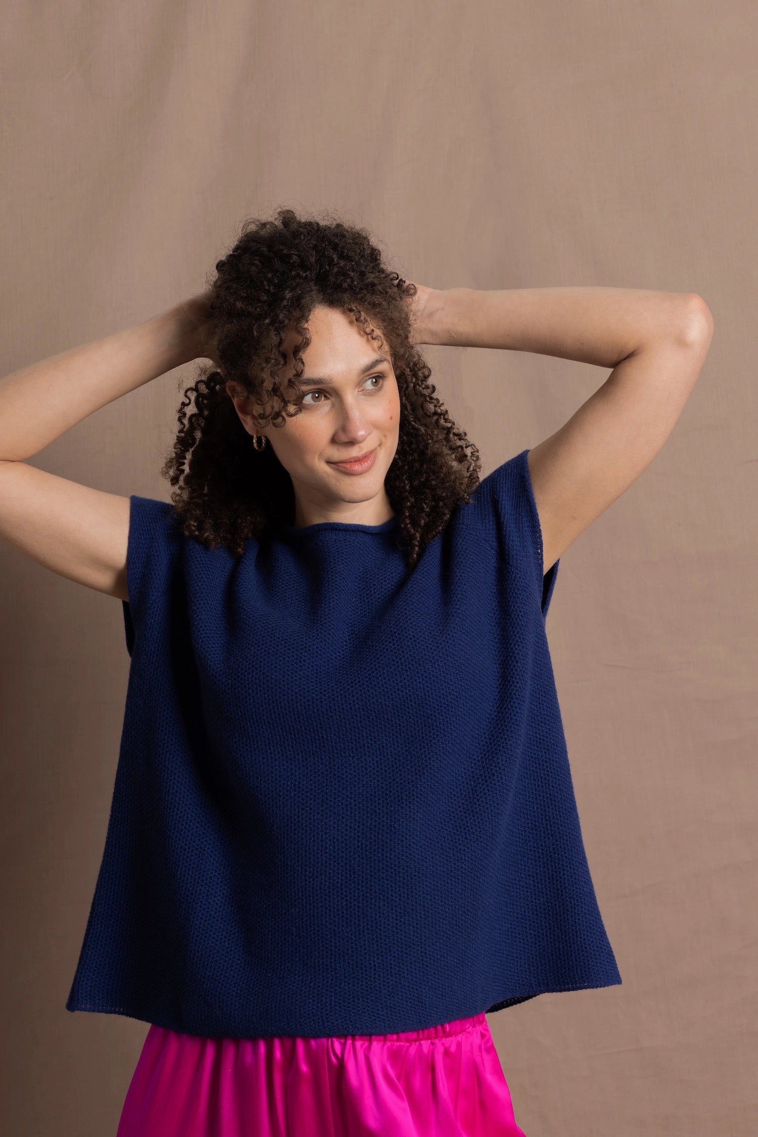 A lady wears a pure 100% cashmere tee sweater jumper in blue over bright pink silk trousers
