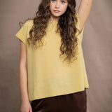 a woman wears a cashmere tee in butter yellow over silk trousers in chocolate brown 
