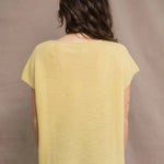 a woman wears a cashmere tee in butter yellow over silk trousers in chocolate brown 