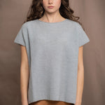 a woman wears a pure 100% cashmere tee sweater in pale light blue turquoise over a bronze silk skirt 