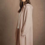 A woman wears a pure cashmere cardigan coat in beige