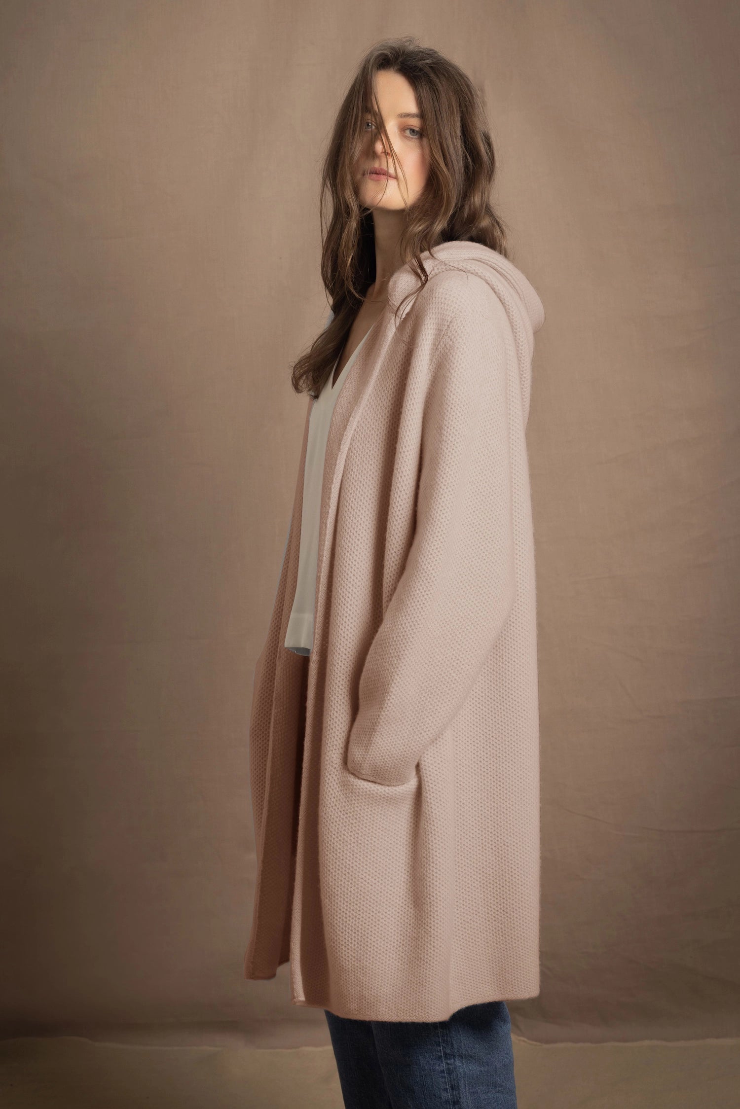 A woman wears a pure cashmere cardigan coat in beige