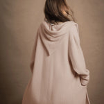 A woman wears a pure cashmere hooded cardigan coat in beige
