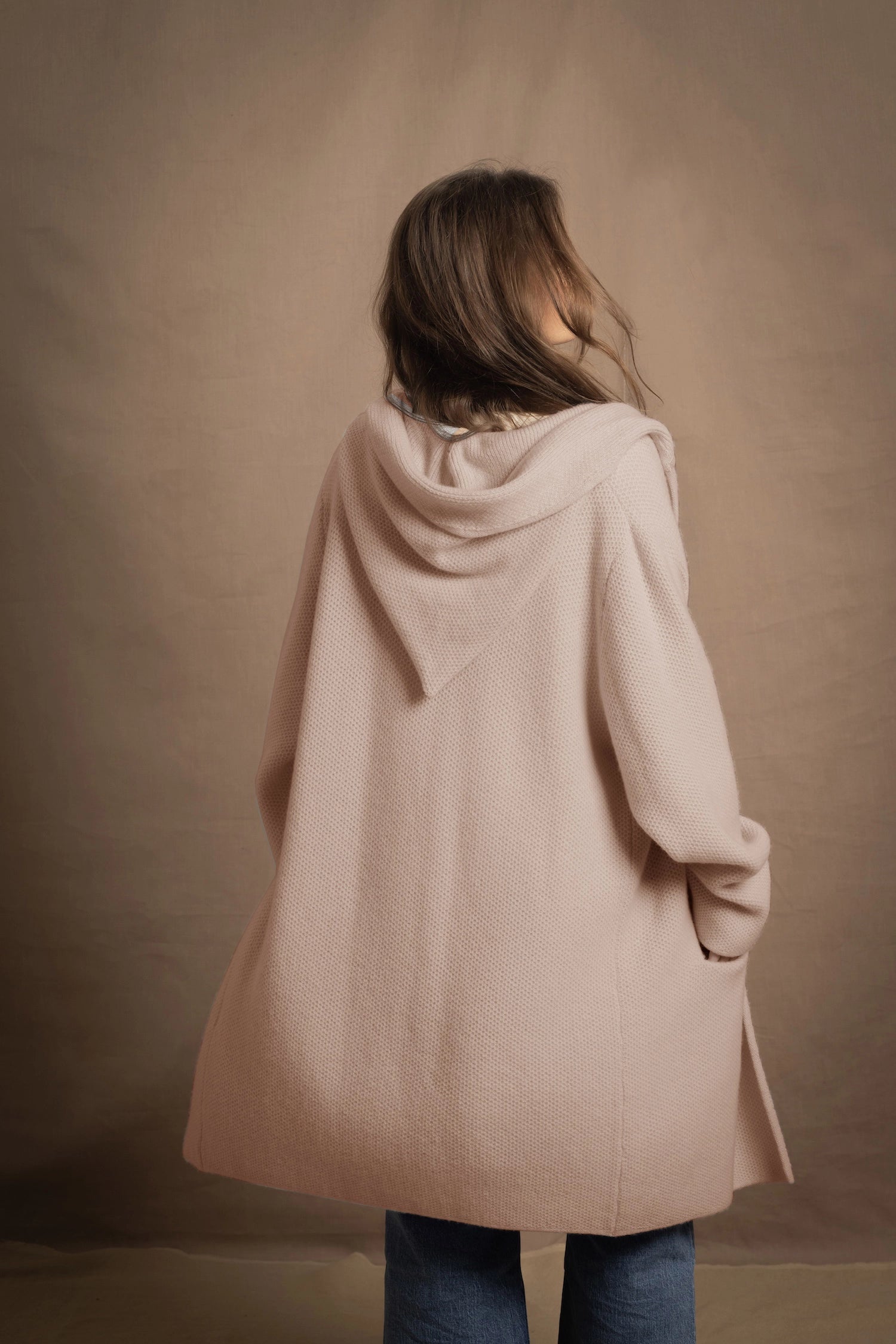 A woman wears a pure cashmere hooded cardigan coat in beige