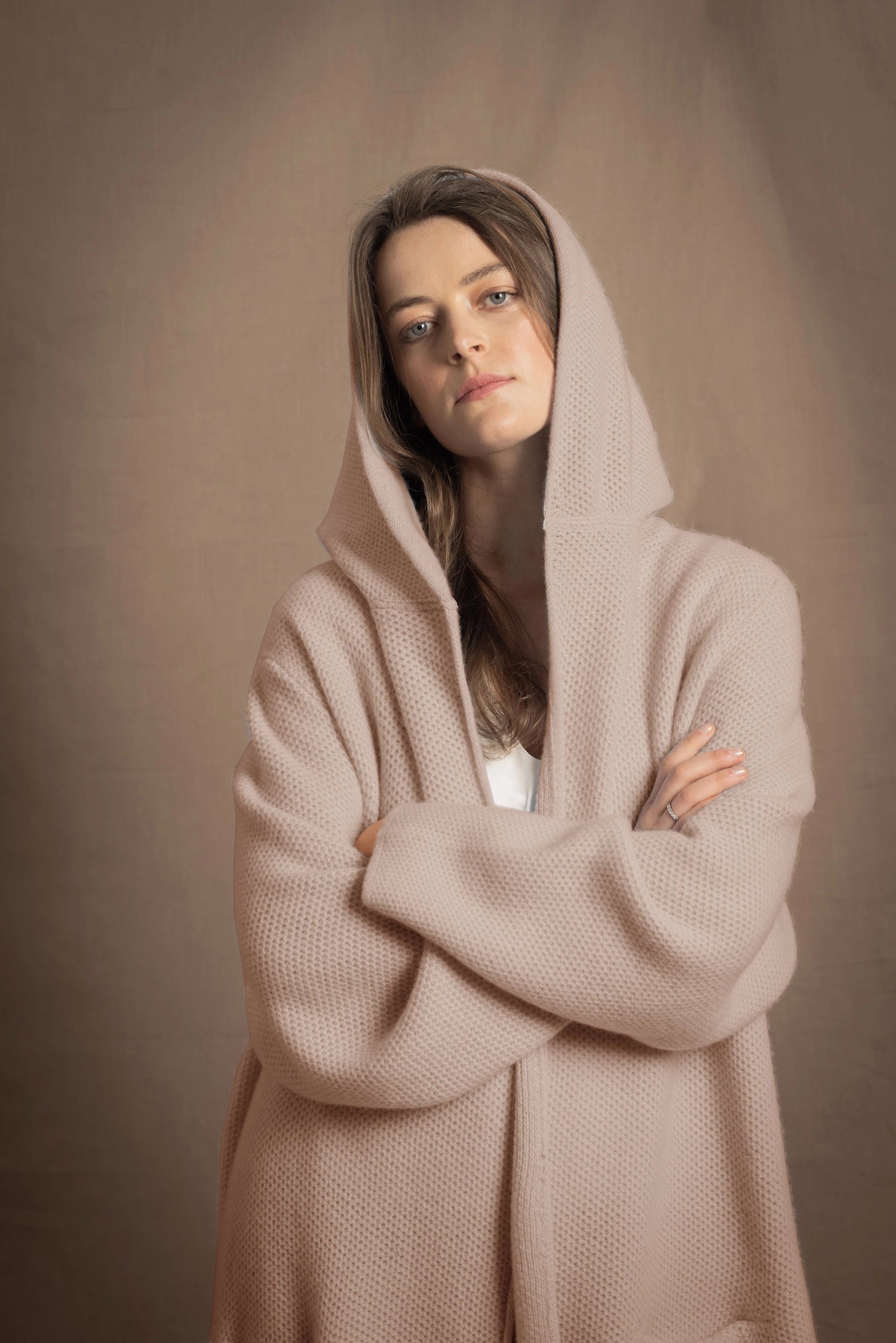 A woman wears a pure cashmere hooded cardigan coat in beige