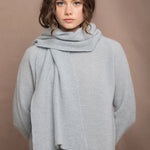 Woman wearing a pale blue cashmere scarf and sweater with a bronze silk skirt