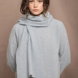 Woman wearing a pale blue cashmere scarf and sweater with a bronze silk skirt