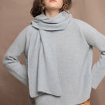 Woman wearing a pale blue cashmere scarf and sweater with a bronze silk skirt