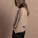 A woman wears a pure cashmere twinset cardigan with matching vest top in Beige with silk shorts in black
