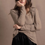 A woman wears a pure cashmere twinset cardigan with matching vest top in Beige with silk shorts in black