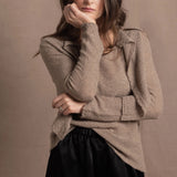A woman wears a pure cashmere twinset cardigan with matching vest top in Beige with silk shorts in black