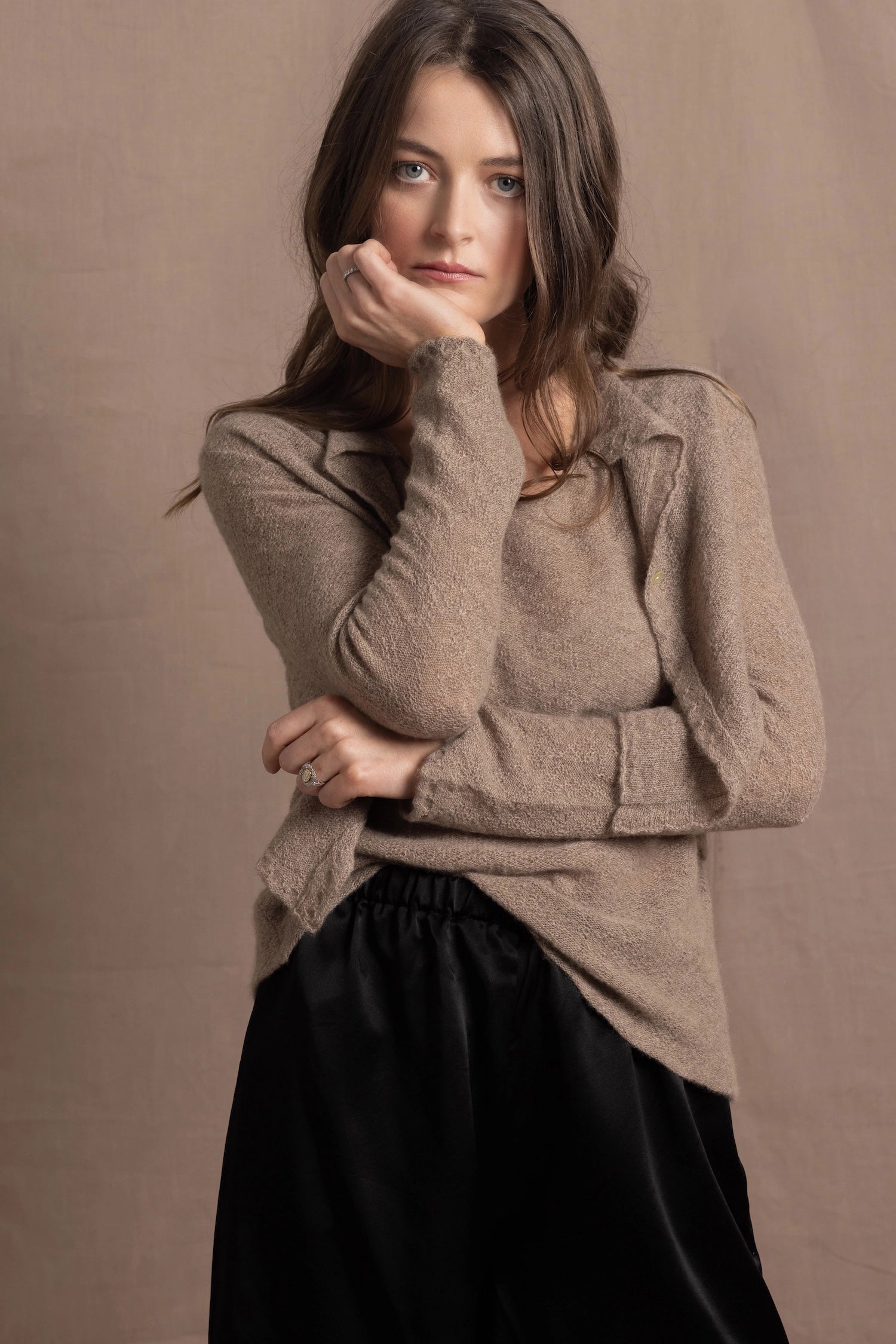A woman wears a pure cashmere twinset cardigan with matching vest top in Beige with silk shorts in black