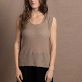 A woman wears a 100% pure cashmere sleeveless vest top in beige with black silk shorts