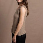 A woman wears a 100% pure cashmere sleeveless vest top in beige