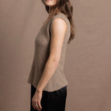 A woman wears a 100% pure cashmere sleeveless vest top in beige