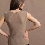 A woman wears a 100% pure cashmere sleeveless vest top in beige