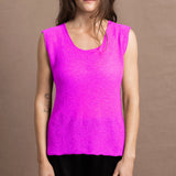 A woman wears a cashmere vest top in neon pink with black silk shorts