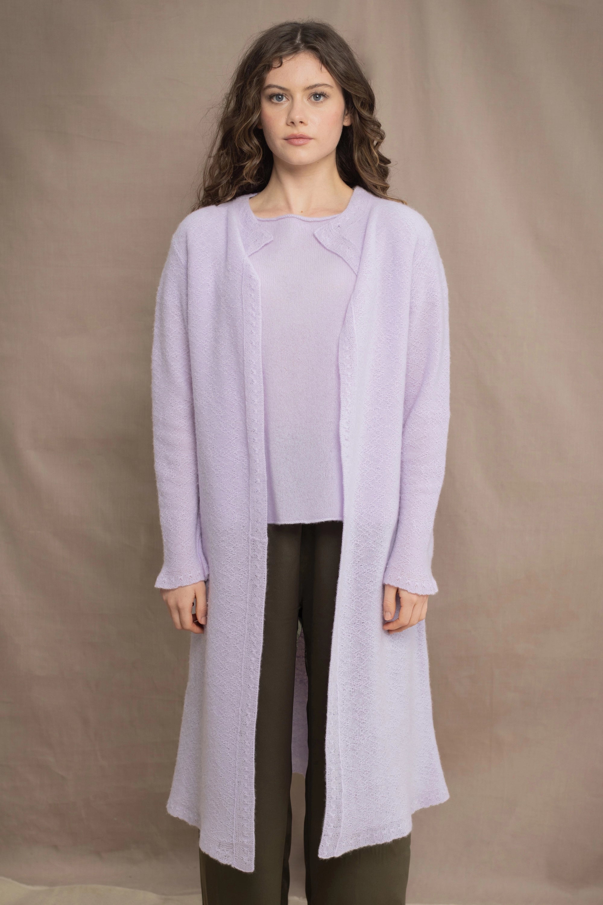 Woman wears a light purple cashmere cardigan coat over a matching cashmere tee sweater by Irish brand Madigan