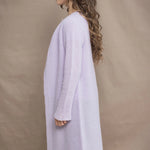 Woman wears a light purple cashmere cardigan coat over a matching cashmere tee sweater by Irish brand Madigan