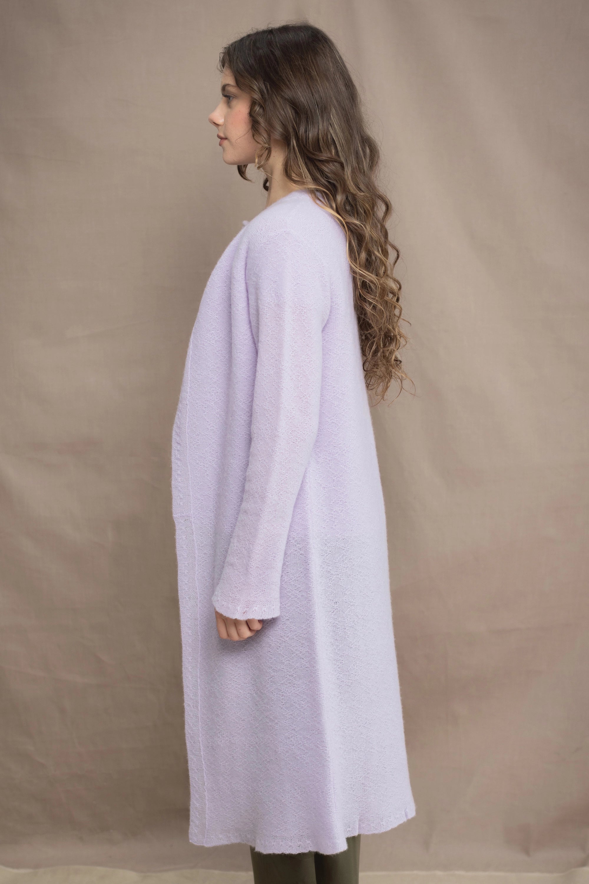 Woman wears a light purple cashmere cardigan coat over a matching cashmere tee sweater by Irish brand Madigan