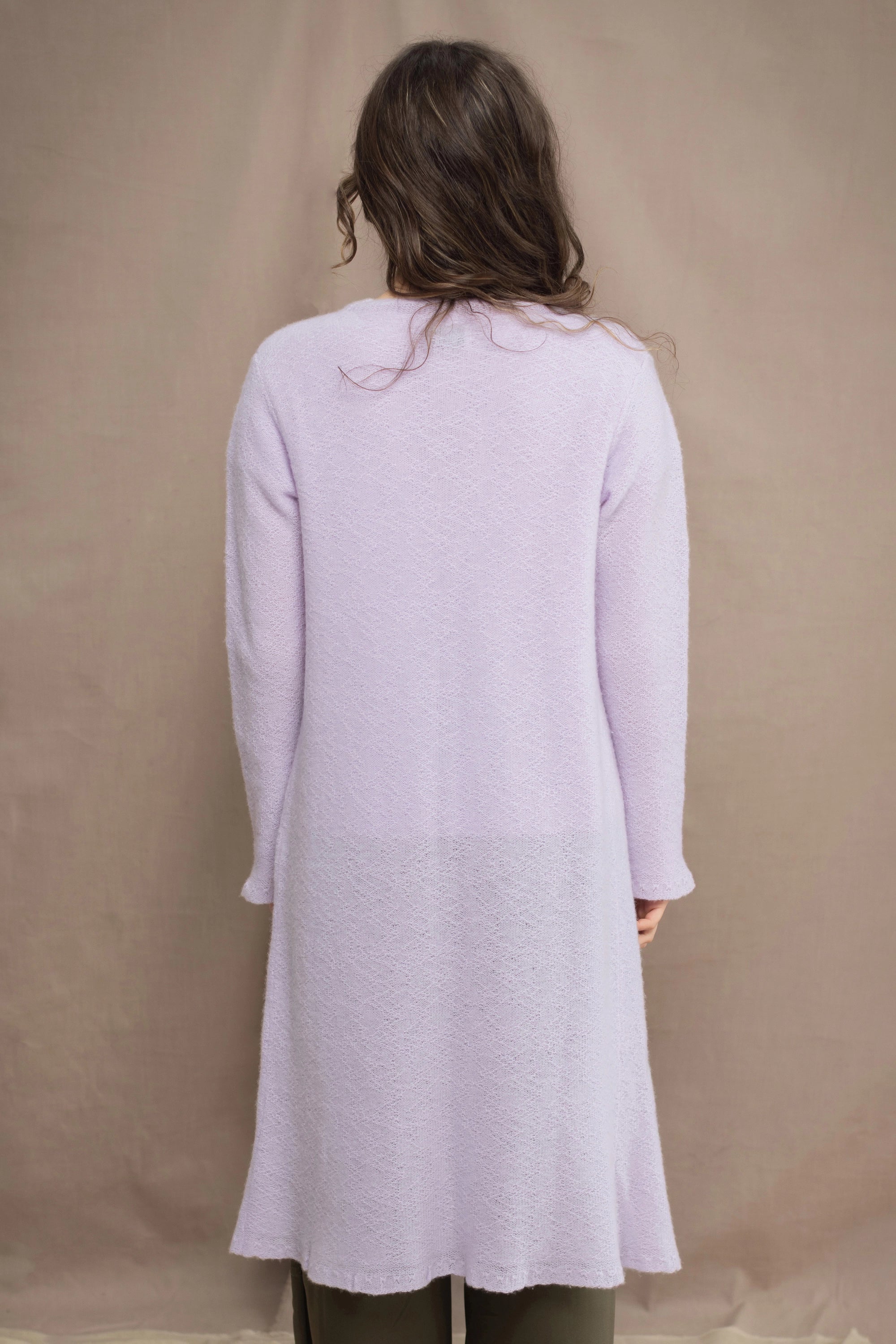 Woman wears a light purple cashmere cardigan coat over a matching cashmere tee sweater by Irish brand Madigan