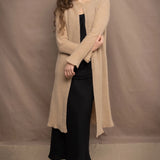 Woman wearing an Irish Linen sleeveless top and skirt  in black with beige cashmere long cardigan on top