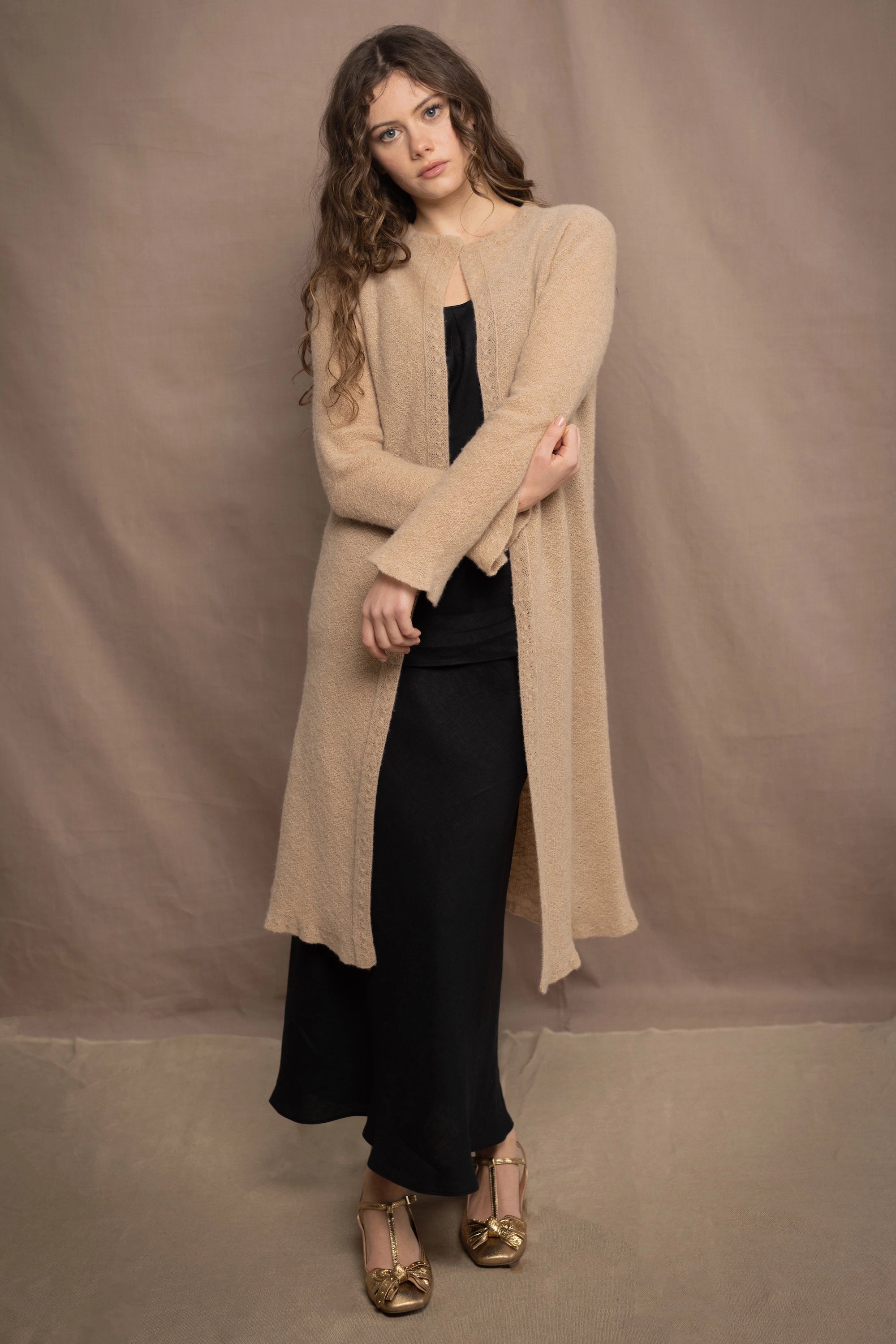 Woman wearing an Irish Linen sleeveless top and skirt  in black with beige cashmere long cardigan on top