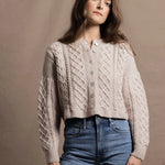 A lady wears a pure 100% cashmere Irish aran sweater cardigan in soft pink 