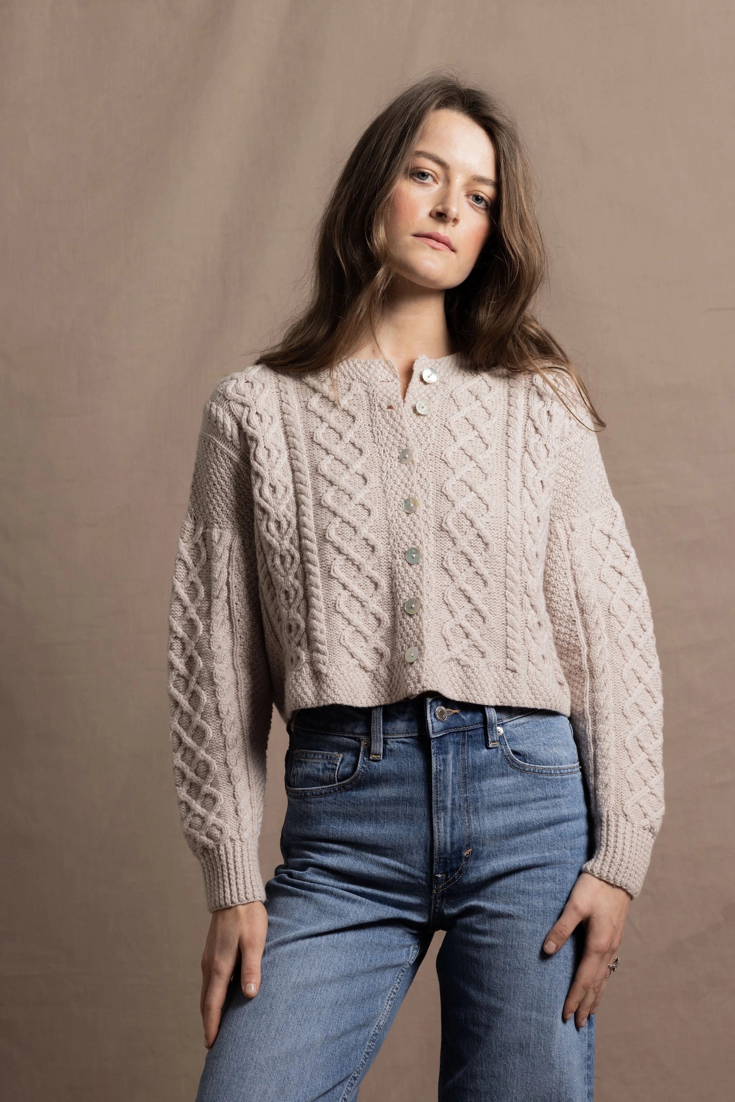 A lady wears a pure 100% cashmere Irish aran sweater cardigan in soft pink 