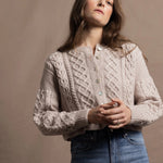 A lady wears a pure 100% cashmere Irish aran sweater cardigan in soft pink 
