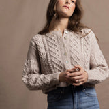 A lady wears a pure 100% cashmere Irish aran sweater cardigan in soft pink 