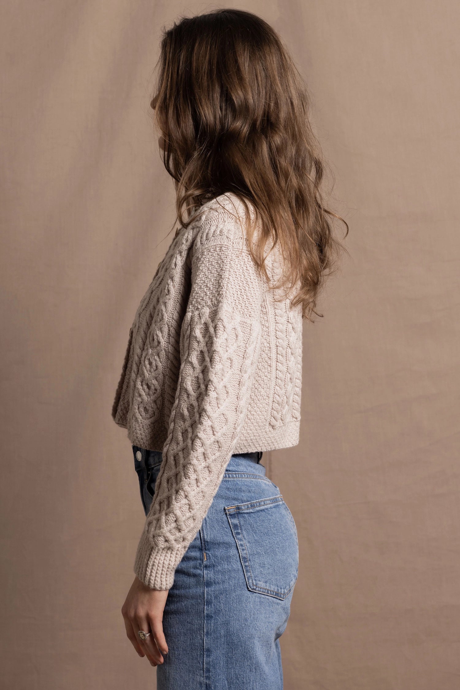 A lady wears a pure 100% cashmere Irish aran sweater cardigan in soft pink 