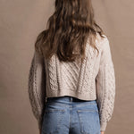 A lady wears a pure 100% cashmere Irish aran sweater cardigan in soft pink 