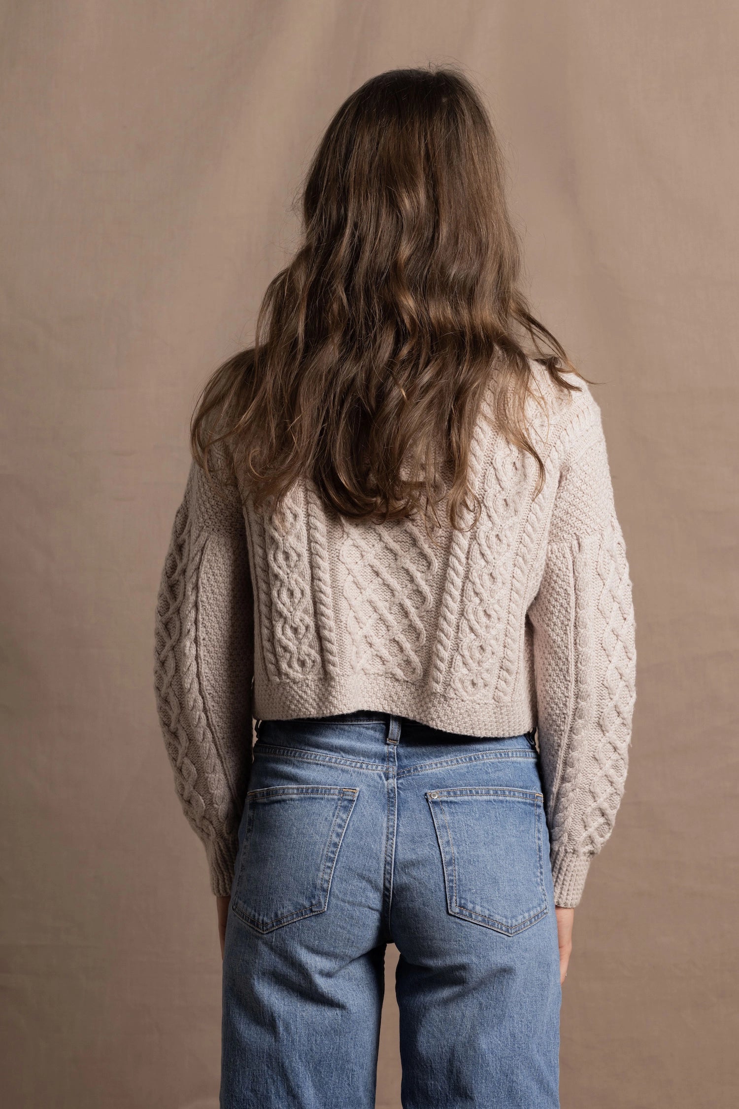 A lady wears a pure 100% cashmere Irish aran sweater cardigan in soft pink 