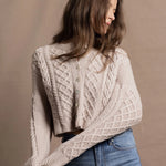 A lady wears a pure 100% cashmere Irish aran sweater cardigan in soft pink 