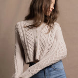 A lady wears a pure 100% cashmere Irish aran sweater cardigan in soft pink 