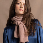 a small 100% cashmere scarf in blush pink over a teal 100% silk top 