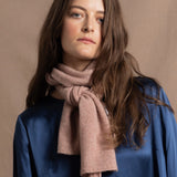 a small 100% cashmere scarf in blush pink over a teal 100% silk top 