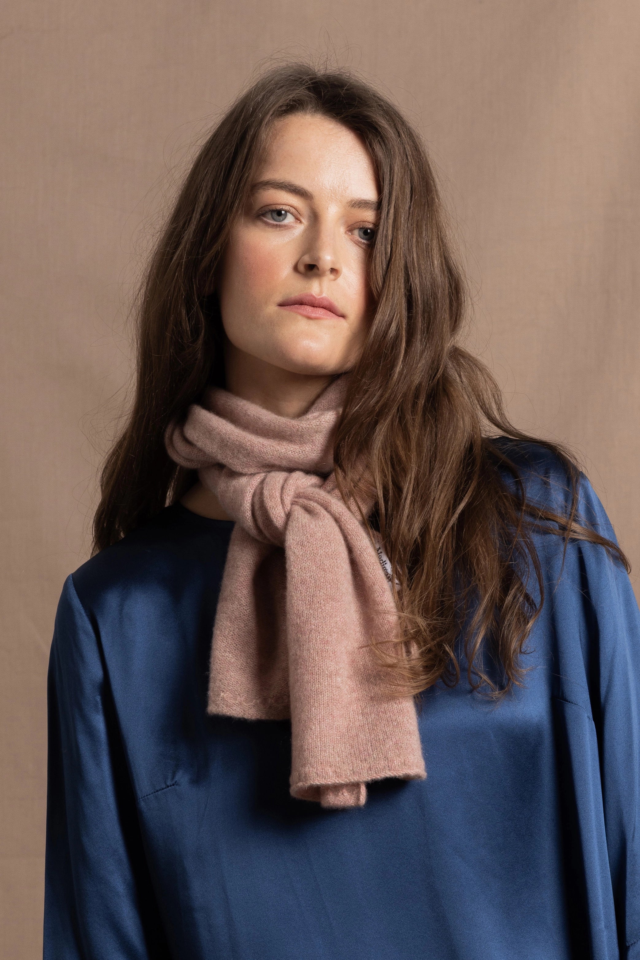 a small 100% cashmere scarf in blush pink over a teal 100% silk top 