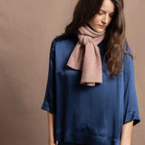 a small 100% cashmere scarf in blush pink over a teal 100% silk top and matching trousers