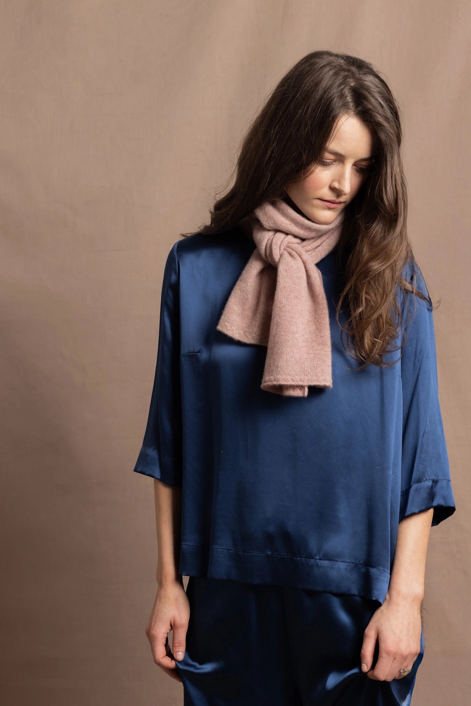 a small 100% cashmere scarf in blush pink over a teal 100% silk top and matching trousers