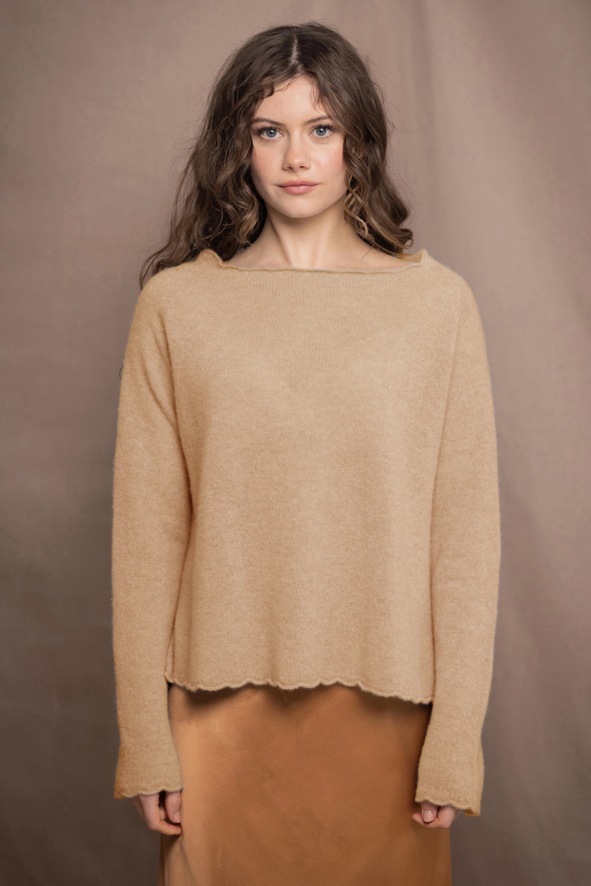 a woman wears a cashmere sweater in sandy beige colour