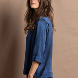 A lady wears a pure silk 3/4 sleeve blouse in teal with matching trousers