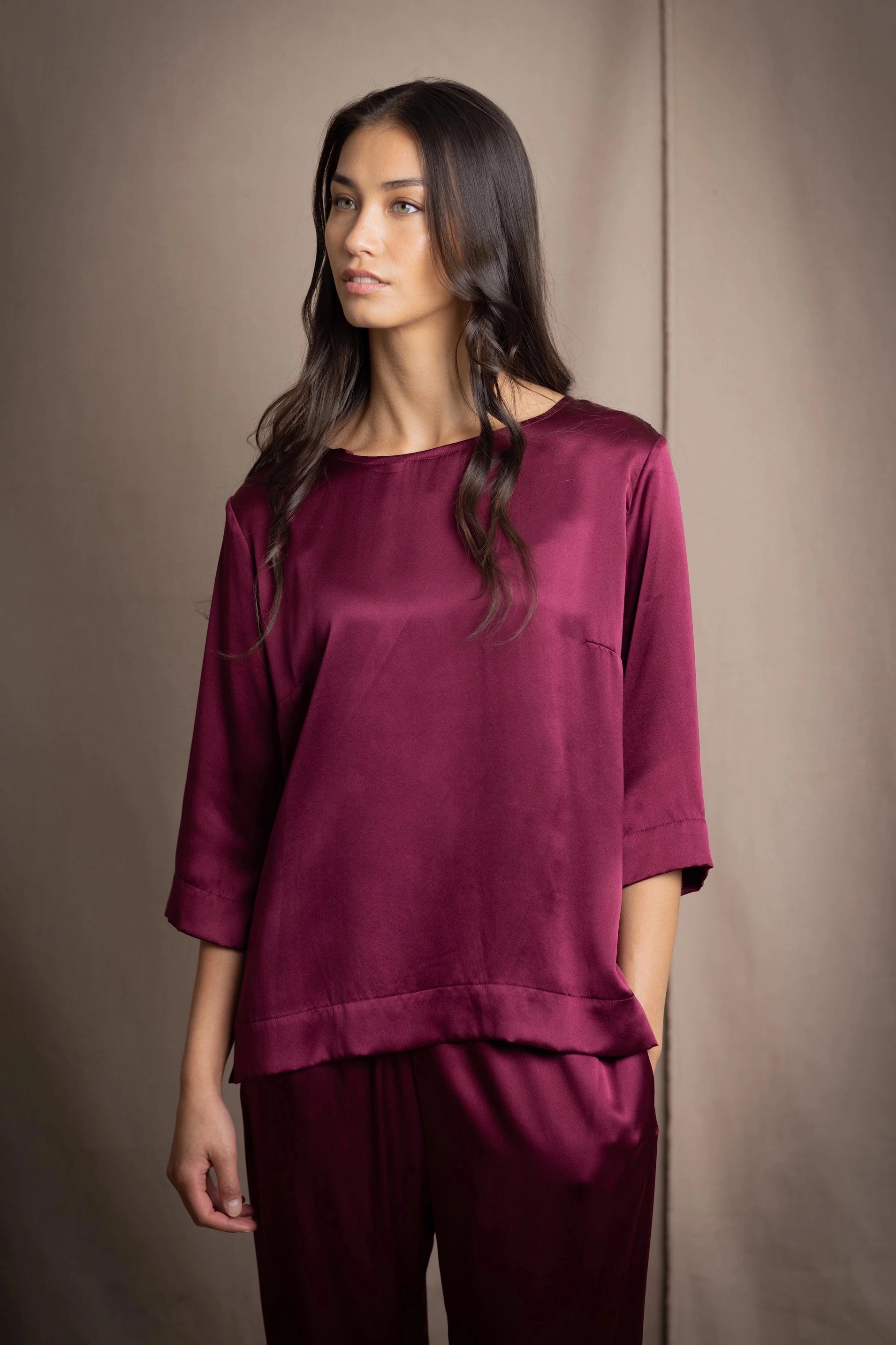 Woman wearing a burgundy silk top and trousers