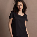 a woman wears a black crew neck short sleeve silk tee and matching trousers