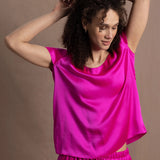 A woman wears a pure 100% silk t-shirt in bright pink with matching trousers