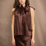 a woman wears a pure 100% silk halter top in chocolate brown with matching silk skirt