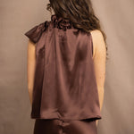 a woman wears a pure 100% silk halter top in chocolate brown with matching silk skirt